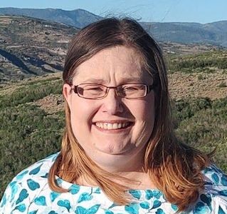 Theresa head in teal leaf shirt w mountains poss website