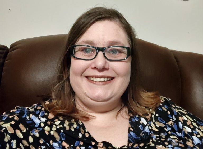 Theresa sitting on couch possible website photo 1 768x566